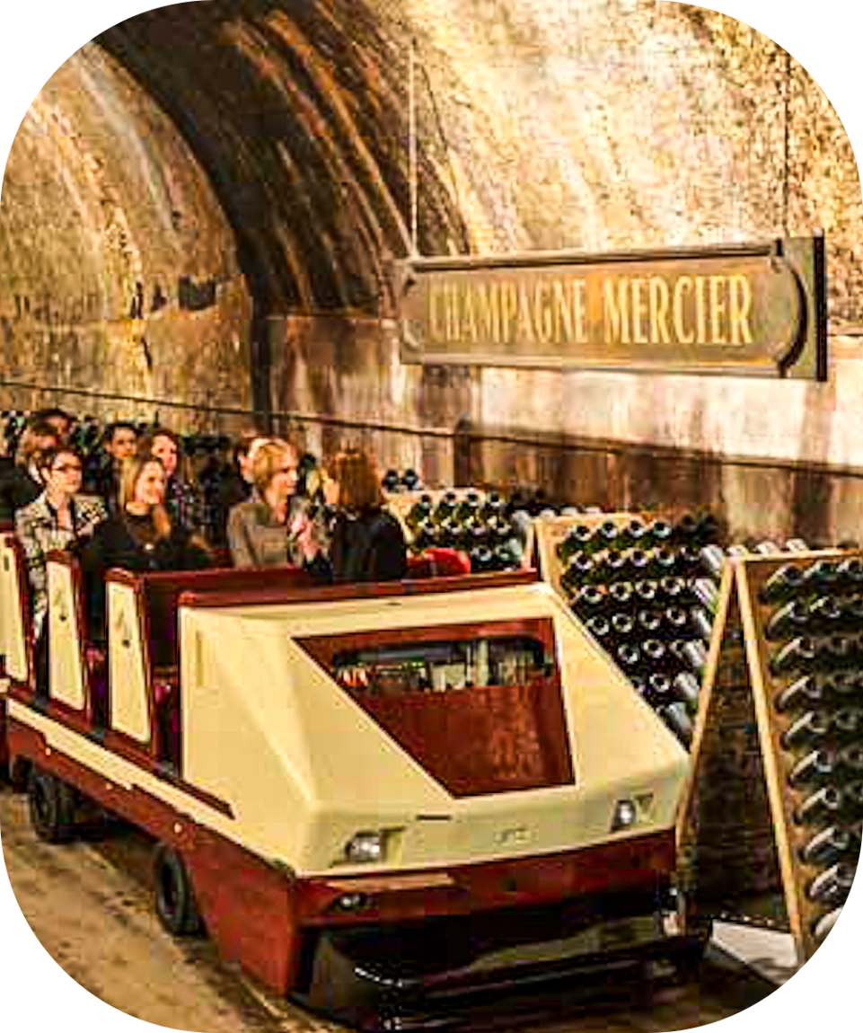 Pessoas num trem de visitação numa Cave na vinícola Mercier